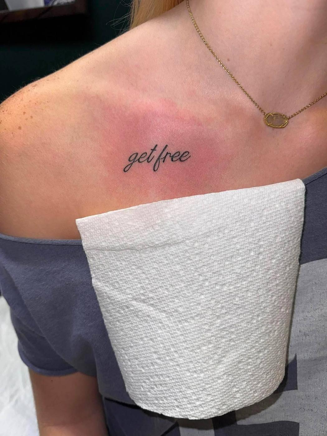 Two words in fine script lettering, tattooed along a collarbone.